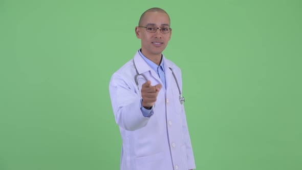 Happy Bald Multi Ethnic Man Doctor Pointing at Camera