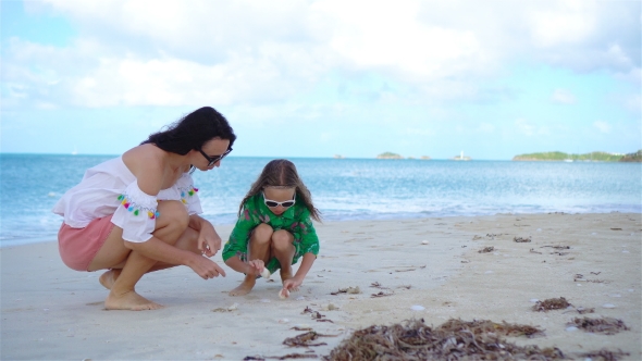 Beautiful Mother and Daughter on Caribbean Beach Looking for Seashells