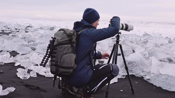 Photographer on Diamond Beach Near Glacier Lagoon of Iceland