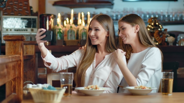 Two Beautiful Women Taking Selfie in Cafe