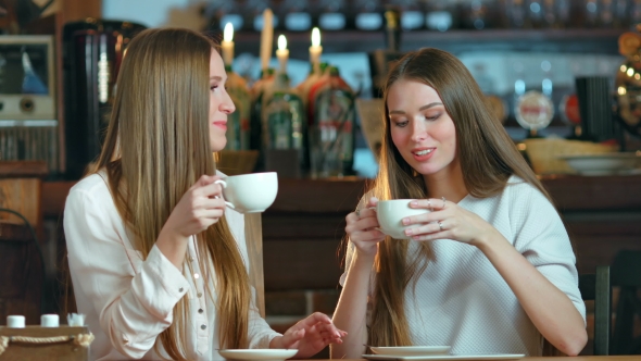 Two Young Female Friends Meeting in Cafe