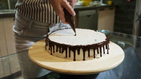 of Woman Hands Preparing a Cake, Pouring the Chocolate Glaze on It.