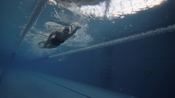 Woman Swimming Crawl Stroke in Blue Water Floating Pool Underwater View