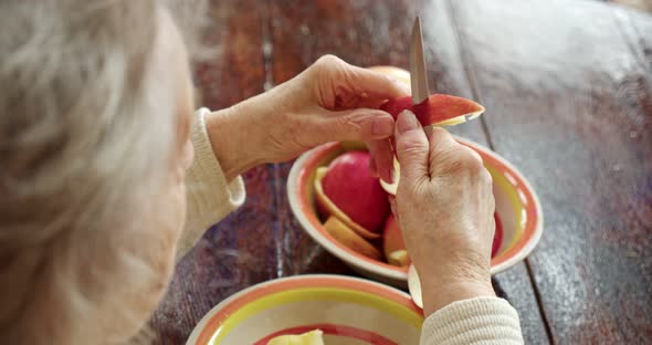 Closeup Grandmother's Old Women's Hands Peel a Ripe Red Apple