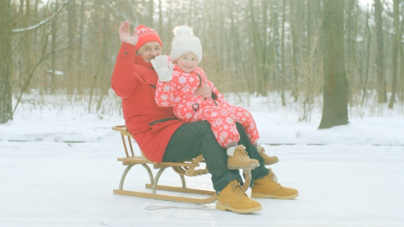 Happy Little Boy and His Grandfather on the Sledge in the Winter Park