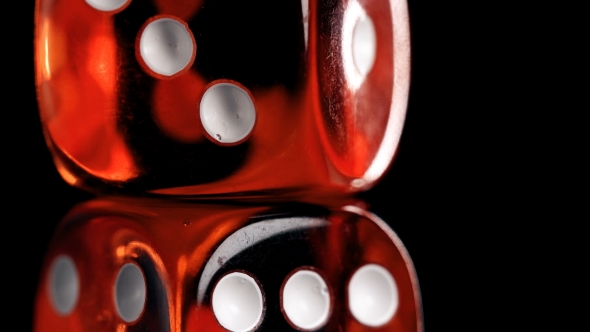 Rotating Red Dice Around Its Axis, on a Black Background