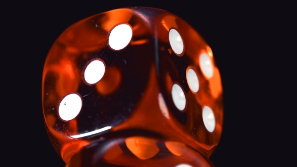 Rotating Red Dice Around Its Axis, on a Black Background
