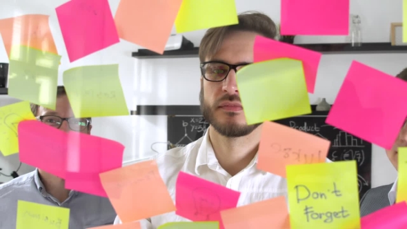 Man Post in Sticky Note While Meeting in Office on the Sticker Is Written IDEA