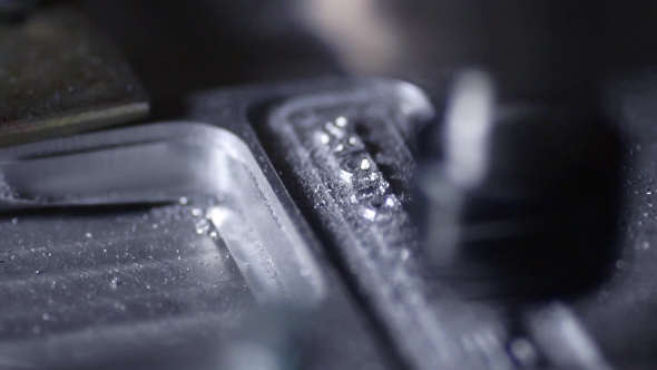 In a Beautiful Light, the Drill Bit Slowly Carves Out the Aluminum Plate Company Name for