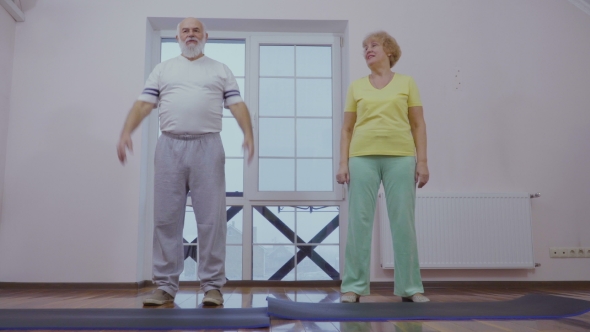 Senior Man with His Wife Makes Sport Exercises at Home Together