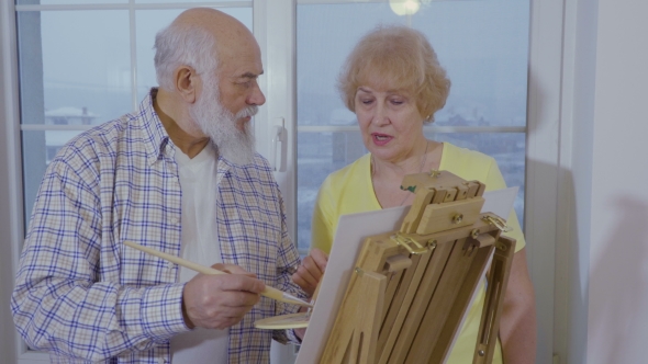 Senior Man with Senior Woman Are Drawing Picture on Easel