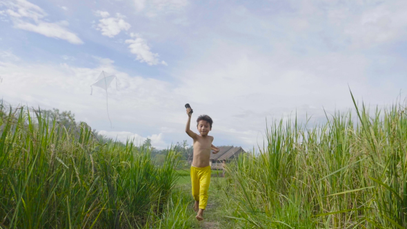 Happy Boys Running With Kite In The Field