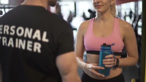 Attractive Female Client Talking to Fitness Coach After Finishing Workout