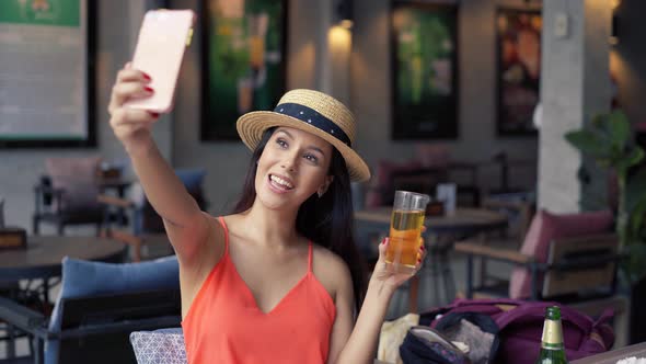 Portrait of Young Brunette Woman Taking a Selfie Photo From Cell Phone in Pub Bar