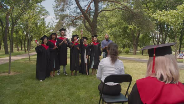 Cheerful Diverse Multiethnic Graduates Celebrating University Degree at Graduation Day