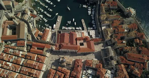 Aerial birds eye view of Dubrovnik Old Town Port. the camera rises slowly to reveal the croatian coa