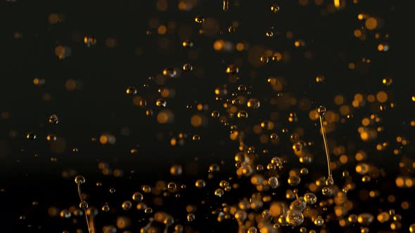 Super Slow Motion Shot of Splashing Oil Drops Isolated on Black Background at 1000Fps