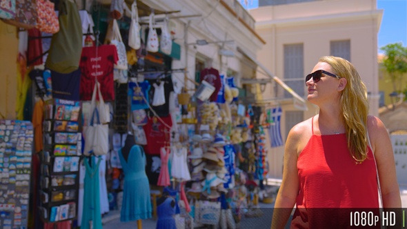 Tourist exploring shopping district with storefronts filled with souvenirs