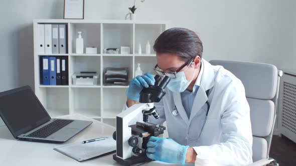 Professional medical doctor working in hospital office using computer technology.