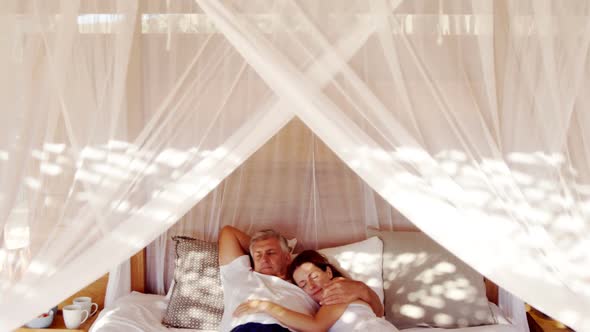 Senior couple sleeping on canopy bed 4k