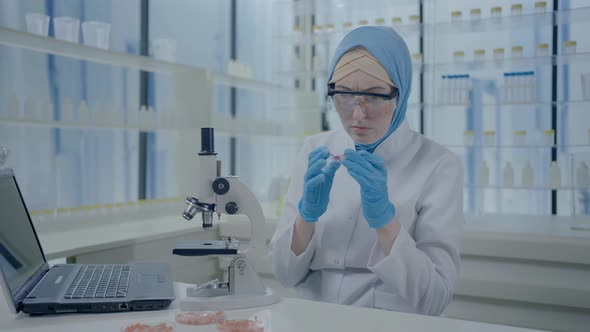 Portrait of a Disgruntled and Puzzled Muslim Female Scientist in a Hijab and White Coat Looking