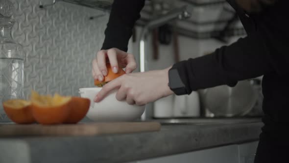 Woman Preparing Orange Juice On Kitchen