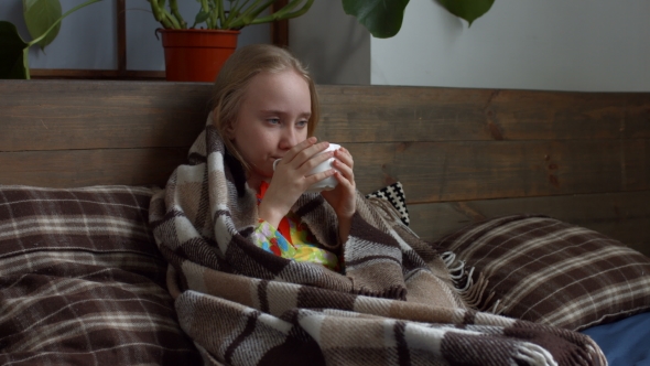 Little Girl Caught Flu and Drinking Hot Tea in Bed alt