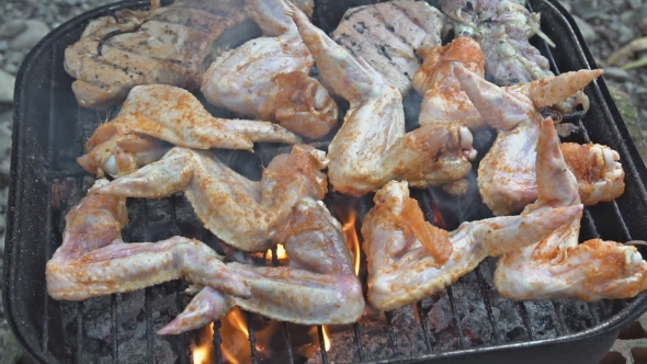Chicken Wings Turned over on a Barbecue Grill