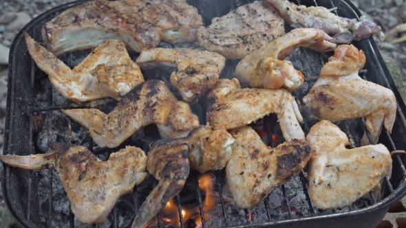 Chicken Wings and Legs Cooking on a Barbecue Grill