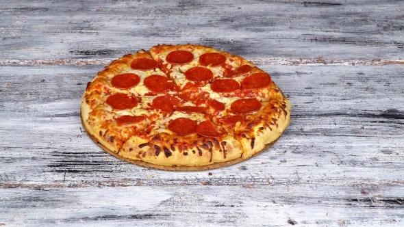 Hand Takes Slice of Hot Nice Tasty Italian Pizza from Wooden Plate Against Table Background