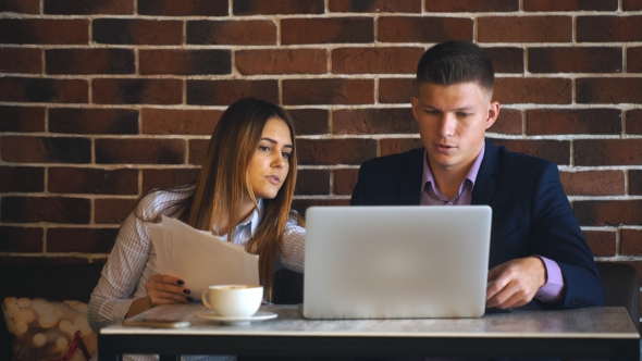 Colleagues Working Together in a Cafe at the Computer