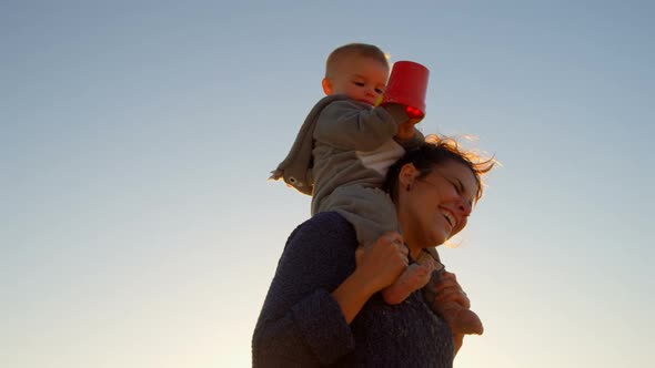 Mother playing with her baby boy in the beach