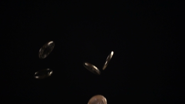 One Euro Coins Fall on a Black Background