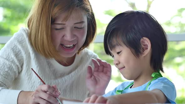 Cute Asian Child And Mother Painting Together