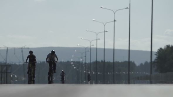 A Group of Cyclists Are Driving Along the Road