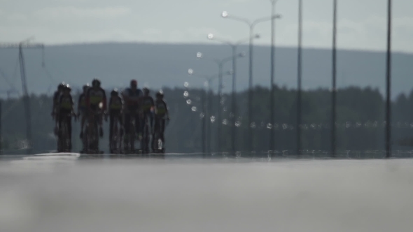 A Group of Cyclists Are Driving Along the Road