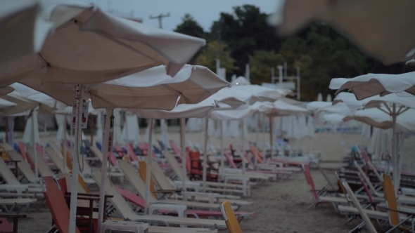 Empty Chaise-longues on Resort in Cloudy Windy Evening