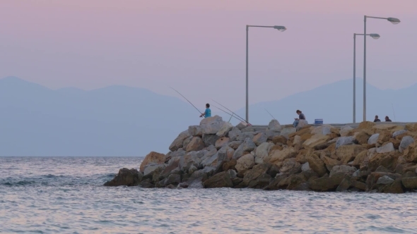 People Fishing and Relaxing on Pier in the Sea