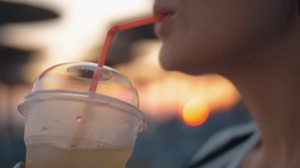 Woman Drinking Iced Lemonade Outdoor at Sunset