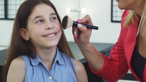 Pretty Little Girl Smiling While Her Mom Applying Makeup on Her Face