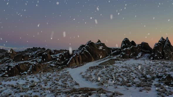 Rocky mountain range during snowfall, aerial drone view