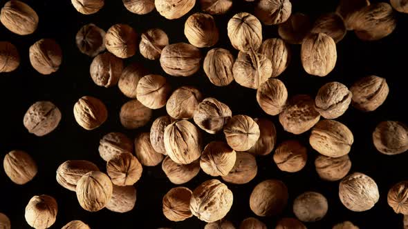 Super Slow Motion Shot of Flying Whole Walnuts Towards Camera Isolated on Black at 1000Fps