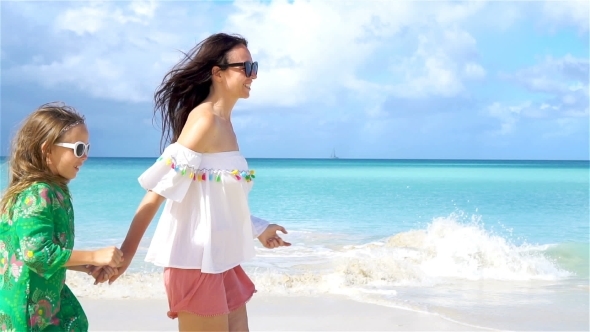 Beautiful Mother and Daughter on Caribbean Beach Walking