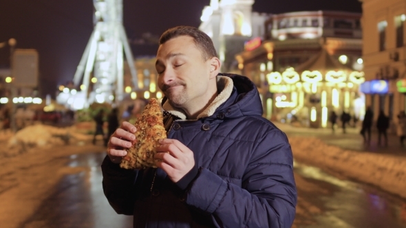Funny Adult Man Eats Pizza at Night City Background