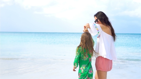 Beautiful Mother and Little Daughter on Caribbean Beach Playing Together