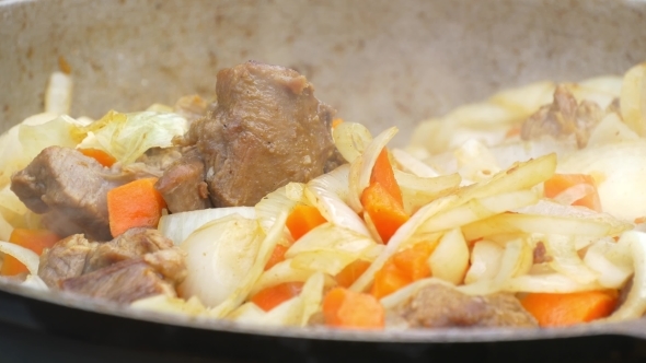 Meat with Rice and Vegetables Is Cooked in a Cauldron at the Stake