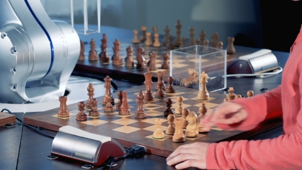 Girl's Hands and a Robotized Arm Are Moving Chess Pieces in Turns