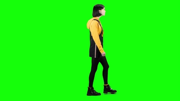 Teen Is Walking Down the Street and Waving Hello . Green Screen. Side View