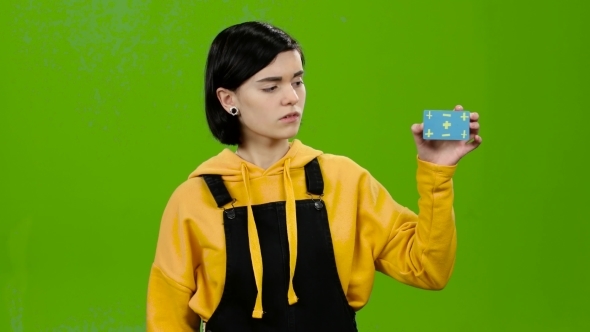 Girl Card in Her Hand and Shows Her Finger Down. Green Screen