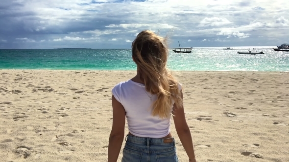 An Attractive Girl Walks Along the Beach and Flirts with the Camera.